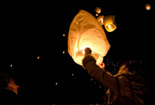 Photograph of young girl setting off a lantern on Christmas Eve in Romania